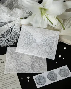 Detailed view of delicate white lace pattern on semi-transparent vellum envelopes set