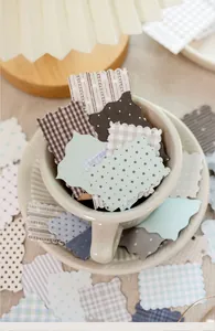 Primo piano di carte decorative retro a quadretti per scrapbooking in una tazza
