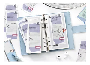 Nahaufnahme von minimalistischem Notizpapier mit lila Gitter in blauem Planer