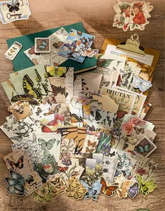 Variety of vintage butterfly scrapbooking stickers and papers displayed on a wooden desk