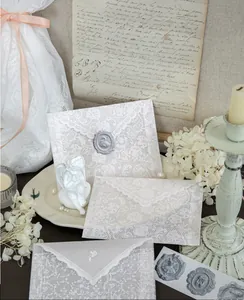 Detailed macro view of elegant white lace patterns on translucent vellum paper envelopes