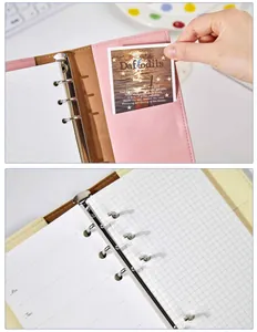 Detailed close-up of the metal rings and grid paper inside this A6 loose-leaf notebook binder