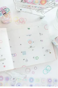 Vista detallada de pegatinas de círculos de colores y cinta washi en una agenda