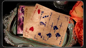 Detailed macro view of vintage Cursed City themed playing cards on a silver tray background.
