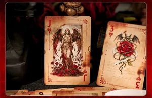 Primo piano di carte da gioco vintage con illustrazioni di angelo oscuro e gargoyle.