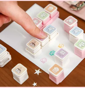 Close-up of pastel leisure life stamps being used on paper for journal decoration.
