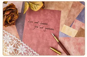 Close-up of vintage textured scrapbook paper sheets with handwritten English quote and fountain pen