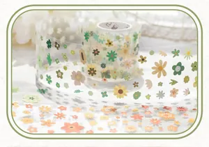 Detail of floral washi tape roll with cute daisy patterns for DIY scrapbooking decor.