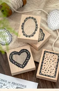 Close-up of vintage beech wood stamps with elegant black lace border patterns for DIY scrapbooking