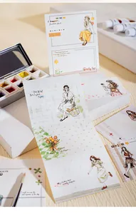 Vue détaillée d'un bloc-notes artistique avec illustrations de filles et aquarelles.