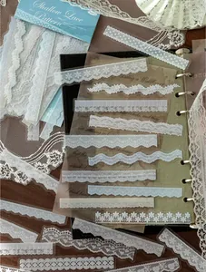 Primo piano dettagliato di vari adesivi in pizzo PET bianco per decorare lo scrapbook.