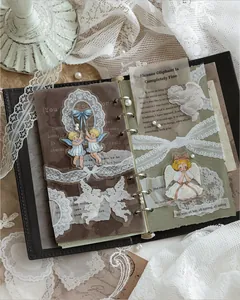 Adesivi in PET con angelo vintage e pizzo bianco che decorano un diario in pelle