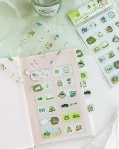 Detail of cute green cartoon index stickers applied to a notebook and in packaging.
