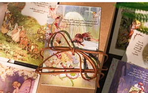 Detailed close-up of vintage European fairy tale postcards with elegant leather string