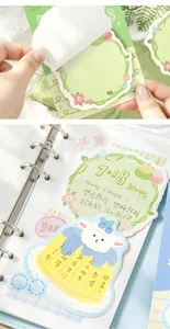Close-up of cute illustrated sticky notes with floral and sheep designs in a notebook