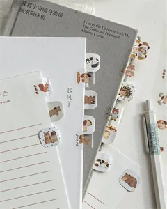 Detail of cute animal index tabs on notebooks and pens in a cozy stationery setup