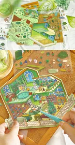 Nahaufnahme von DIY 3D-Szenenaufklebern mit einem grünen Miniatur-Hüttenszenendetail.