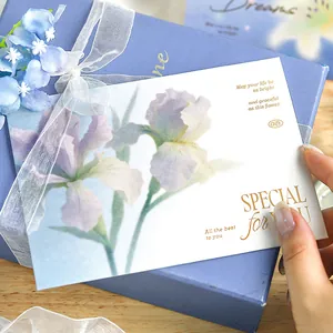 Elegant greeting card with iris floral illustration and gold foil text on a gift box.