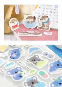 Vue détaillée d'autocollants mignons en feutrine avec loutres et koalas pour journal