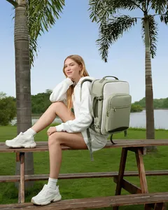 Lifestyle shot showing the sage green large capacity travel backpack worn outdoors.