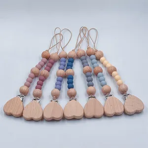 Handmade silicone bead pacifier clips featuring natural beechwood heart attachments
