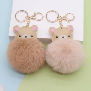Detailansicht von zwei kreativen Bären-Kunstpelz-Pompon-Schlüsselanhängern in Braun und Rosa