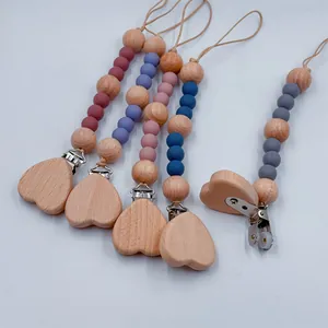 Detailed view of heart-shaped beech wood pacifier clips with colorful silicone beads