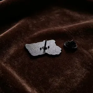 Detailed macro view showing the metal back and butterfly clutch of an enamel pin badge.