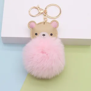 Detailansicht eines rosa Kunstfell-Pompon-Schlüsselanhängers mit Lederbär-Charm