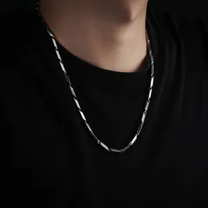 Collier minimaliste en acier titane avec maillons en bambou porté par un mannequin homme