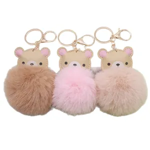 Drei süße Bären-Bommel-Schlüsselanhänger in Braun, Rosa und Beige mit Goldbeschlägen.