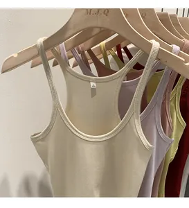Close-up showing the soft ribbed texture of colorful knitted tank tops on wooden hangers.