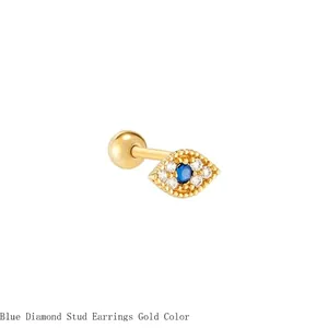 Macro detail of the gold evil eye stud earring featuring blue and clear zircon stones.