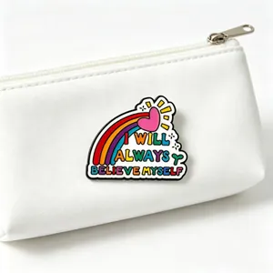 Detailed view of inspirational enamel pin 'I WILL ALWAYS BELIEVE MYSELF' on white pouch