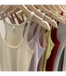 Macro view of various colorful ribbed knitted tank tops hanging on wooden hangers