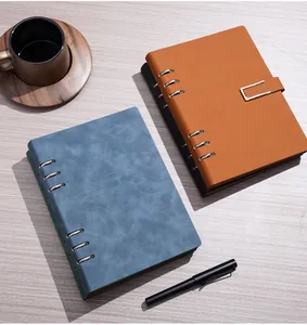 Vista superior de cuadernos de hojas sueltas de cuero A5 premium sobre escritorio de madera