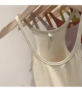 Detailed view of several multi-colored ribbed knitted tank tops hanging on wooden hangers