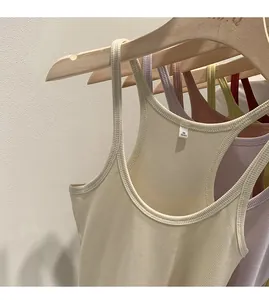 Detailed close-up showing multiple colors of ribbed knit tank tops on wooden hangers.