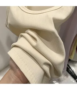 Detailed macro view of cream ribbed knit tank top showing high-quality fabric texture