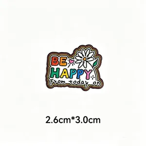 Detailed macro view of colorful 'BE HAPPY' enamel pin badge with 2.6cm x 3.0cm size
