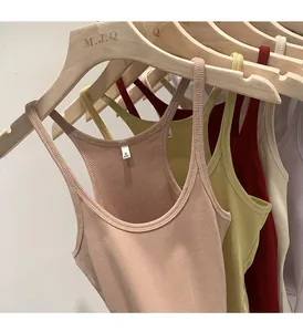 Detailed view of slim fit ribbed knit tank tops in various colors hanging on wooden hangers.