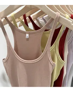 Close-up of slim-fit ribbed knit tank tops in various colors on wooden hangers.