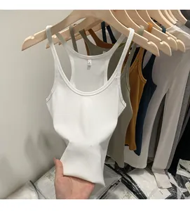 Close-up of slim-fit ribbed knit tank tops in various colors hanging on wooden hangers