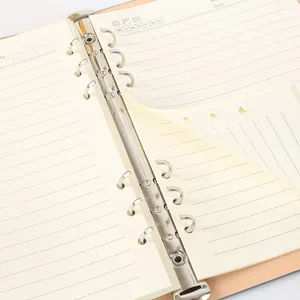 Close-up of a loose-leaf binder notebook interior with metal rings and lined paper