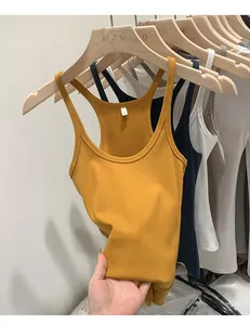 Close-up of ribbed knit tank tops in various colors hanging on stylish wooden hangers.