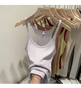 Variety of slim fit ribbed knit tank tops in pastel colors hanging on wooden hangers