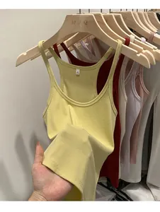 Detailed macro view of multi-color slim fit ribbed knit tank tops on wooden hangers.