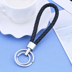 Vue détaillée de la corde en cuir PU tressé noir et de l'anneau de porte-clés en métal argenté.