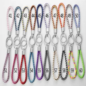 Variété de porte-clés en cuir PU tressé coloré avec anneaux métalliques sur deux rangs.
