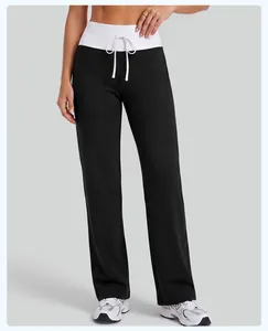 Detail view of women's high-waist black yoga pants with white fold-over drawstring
